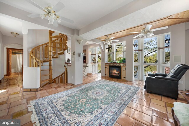 12330 Potomac View Rd, Newburg, MD 20664 - living room featuring stairs, ceiling fan, arched walkways, and a glass covered fireplace