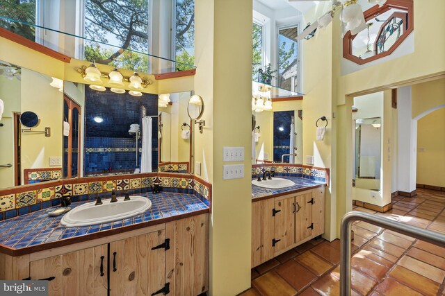12330 Potomac View Rd, Newburg, MD 20664 - full bathroom featuring a towering ceiling, two vanities, backsplash, tile patterned floors, and a chandelier