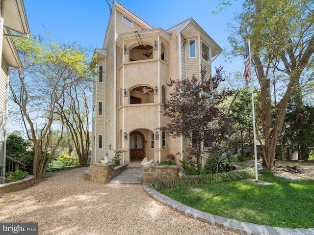 view of front of house with a balcony and a front yard