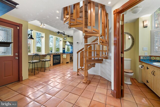 12330 Potomac View Rd, Newburg, MD 20664 - entryway with stairway, light tile patterned flooring, a glass covered fireplace, wine cooler, and rail lighting