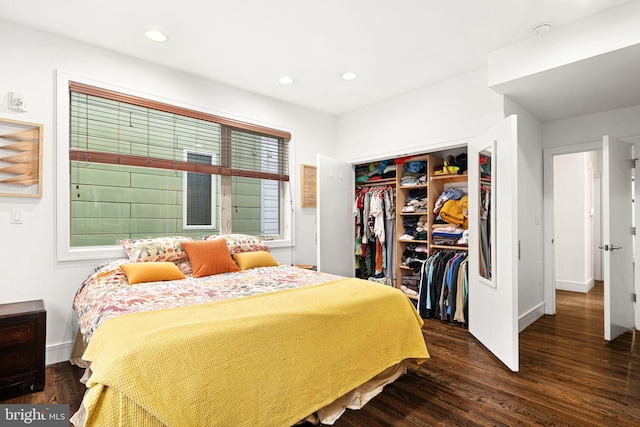 bedroom with dark hardwood / wood-style flooring and a closet