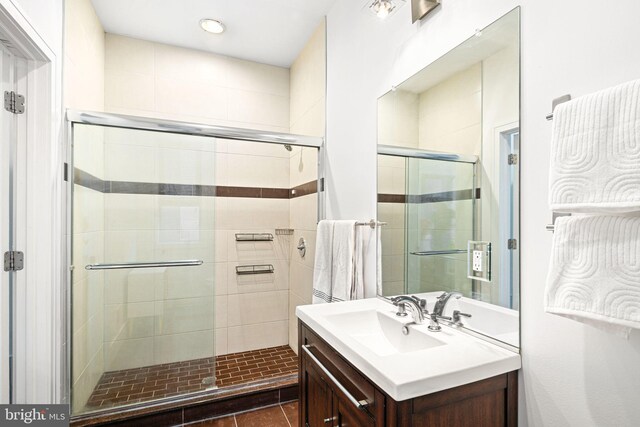 bathroom with tile patterned flooring, vanity, and a shower with shower door