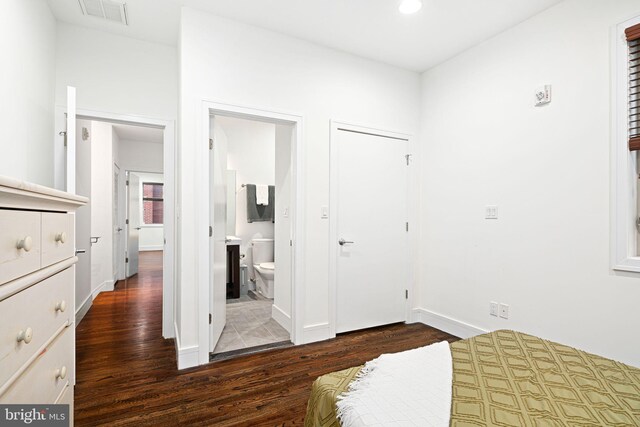 bedroom with dark hardwood / wood-style floors and ensuite bathroom