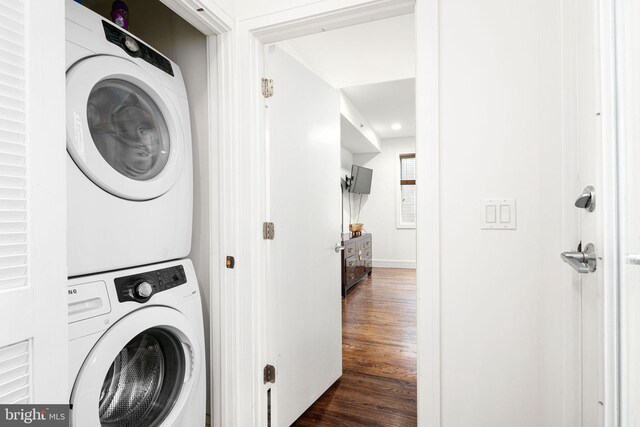 washroom with dark hardwood / wood-style floors and stacked washer / dryer