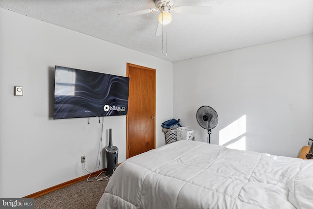 carpeted bedroom featuring ceiling fan and a textured ceiling