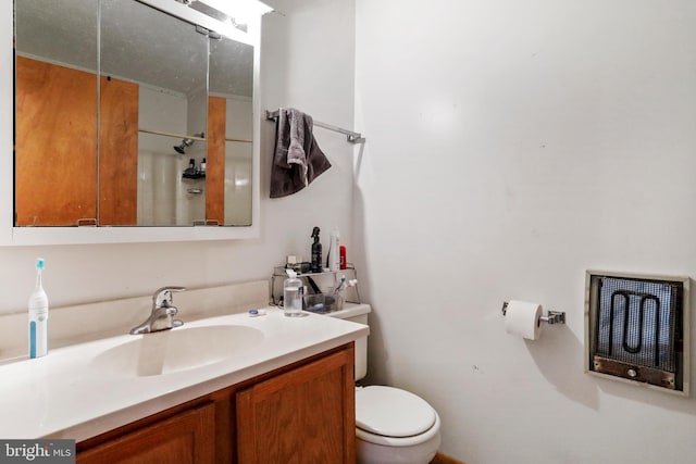 bathroom with walk in shower, vanity, and toilet