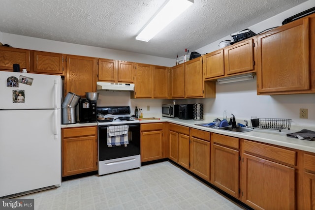 kitchen with a textured ceiling, sink, and white appliances