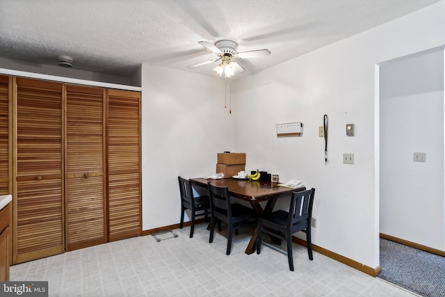 dining area featuring ceiling fan and a textured ceiling