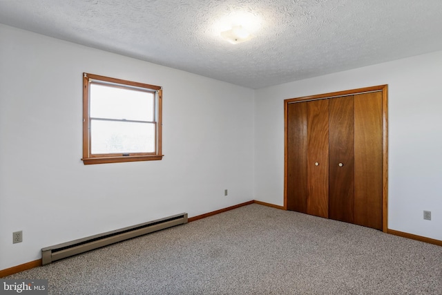 unfurnished bedroom with a closet, carpet, a textured ceiling, and a baseboard heating unit