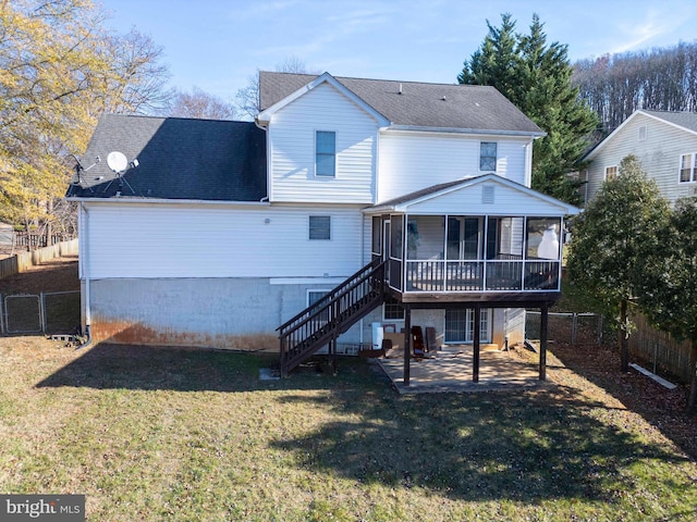 rear view of house with a lawn, a sunroom, and a patio