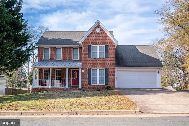 view of front of home with covered porch, a garage, and a front lawn