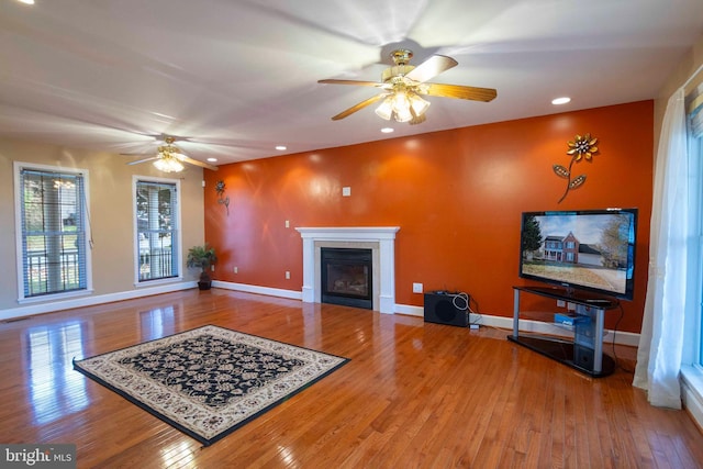 living room featuring a fireplace, ceiling fan, and hardwood / wood-style floors