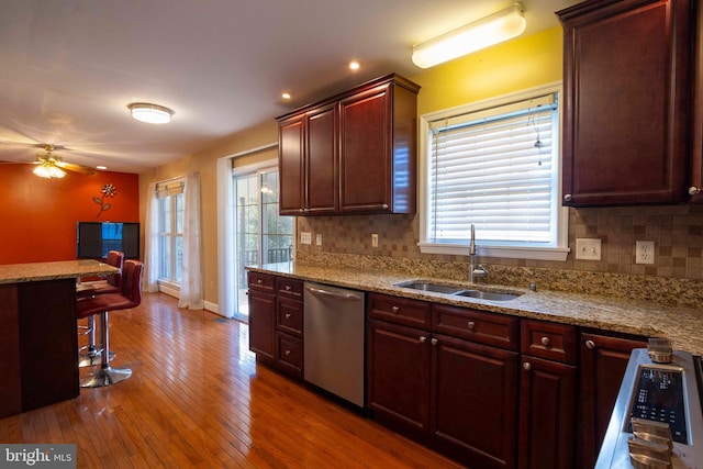 kitchen with a healthy amount of sunlight, sink, stainless steel dishwasher, and dark hardwood / wood-style floors