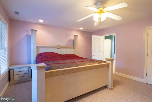 bedroom with ceiling fan, light carpet, and multiple windows