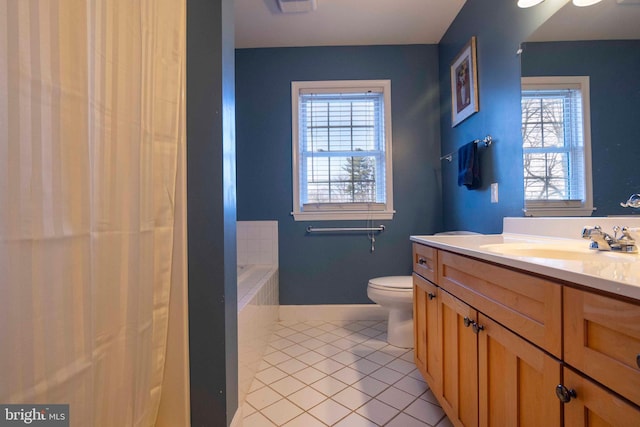 bathroom featuring tile patterned flooring, vanity, a tub to relax in, and toilet