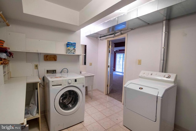 laundry room with washer and clothes dryer, light tile patterned floors, and sink