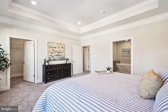 bedroom with light carpet, ornamental molding, a spacious closet, connected bathroom, and a tray ceiling