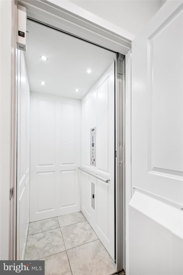 bathroom featuring elevator and tile patterned floors