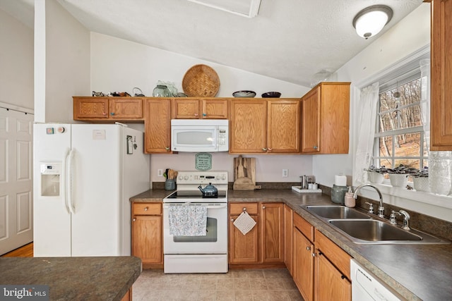 kitchen with a textured ceiling, white appliances, sink, and vaulted ceiling