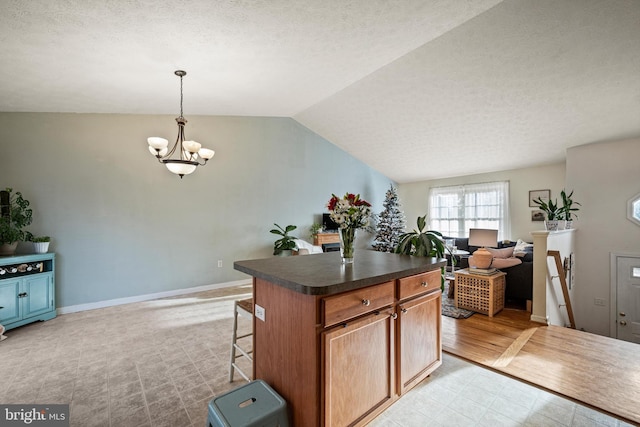 kitchen with a center island, an inviting chandelier, decorative light fixtures, lofted ceiling, and light wood-type flooring