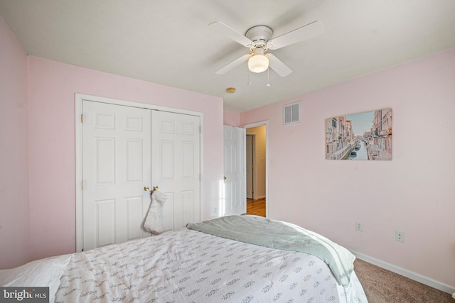 bedroom with ceiling fan, a closet, and light carpet