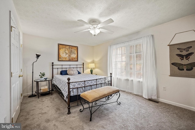 carpeted bedroom with ceiling fan and a textured ceiling