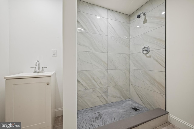 bathroom featuring a tile shower and vanity