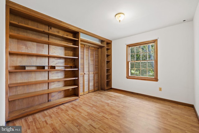 unfurnished bedroom with light hardwood / wood-style floors and a closet