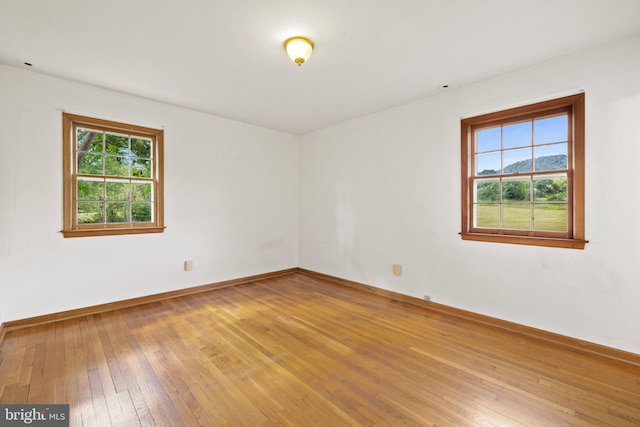 empty room with hardwood / wood-style floors and a mountain view