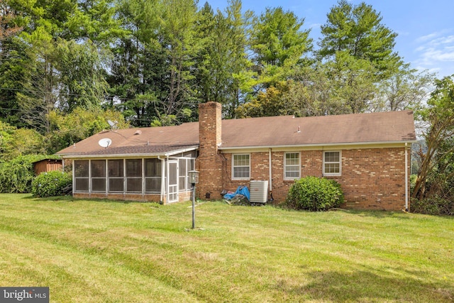 rear view of house featuring a yard, central AC, and a sunroom