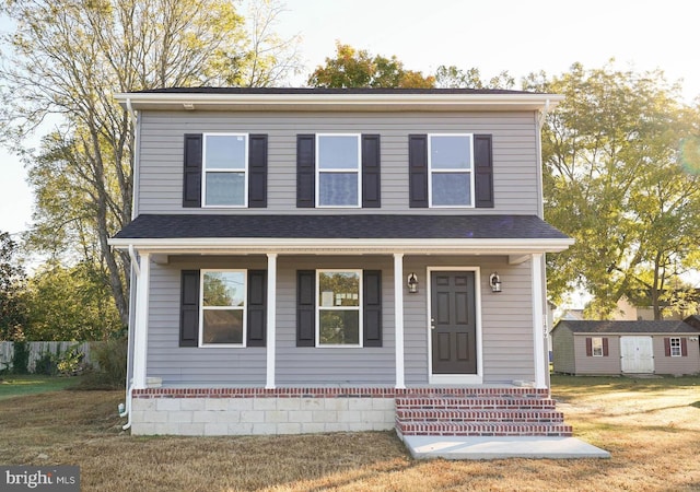 view of front of property featuring a front yard and a storage shed