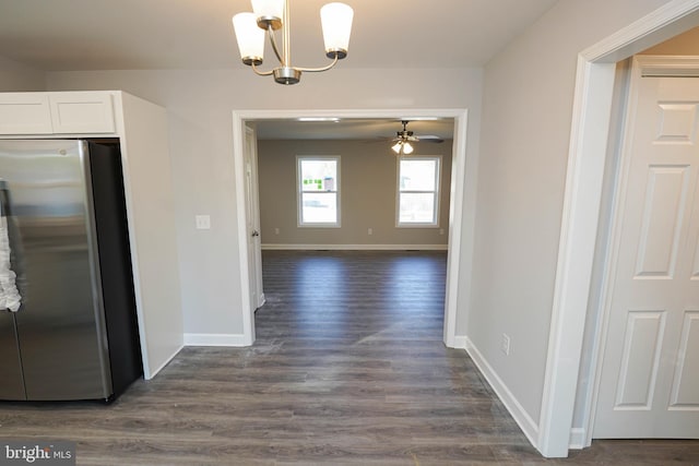 interior space featuring ceiling fan with notable chandelier and dark hardwood / wood-style flooring