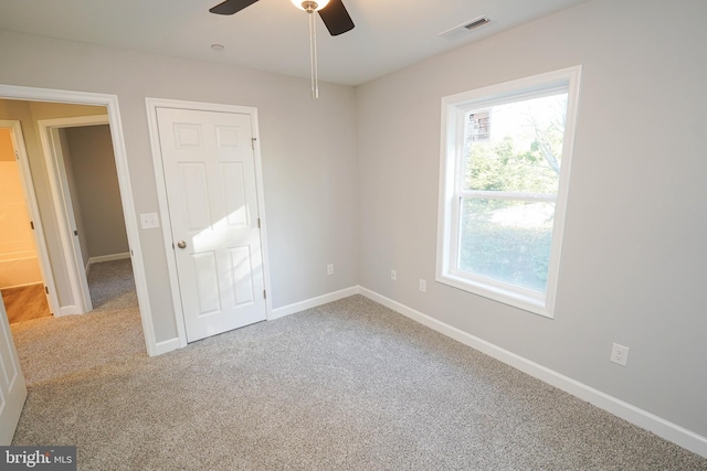 carpeted spare room featuring ceiling fan