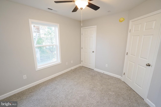 carpeted spare room featuring ceiling fan