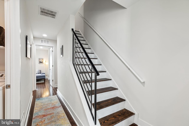 stairs with wood-type flooring and washer / dryer