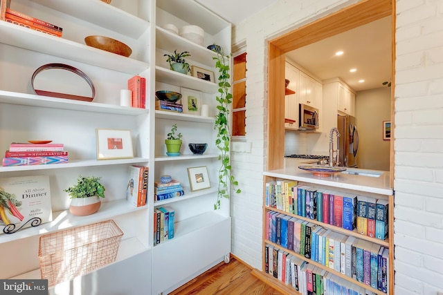 room details with stainless steel appliances, sink, and wood-type flooring