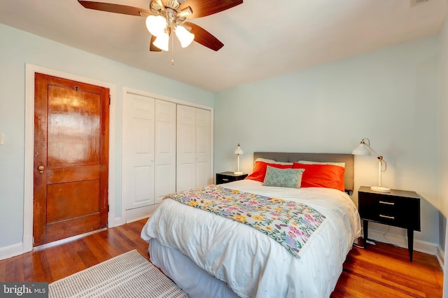 bedroom with dark wood-type flooring, a closet, and ceiling fan