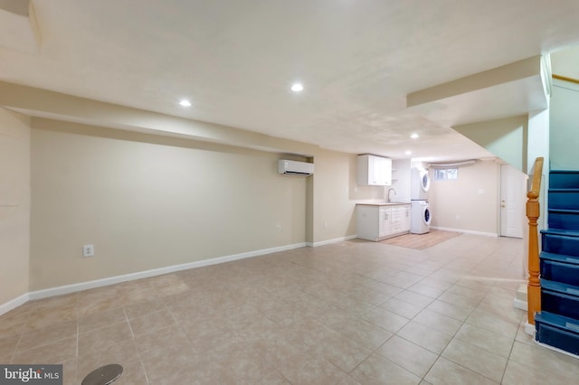 basement with a wall mounted air conditioner, washer / clothes dryer, and sink