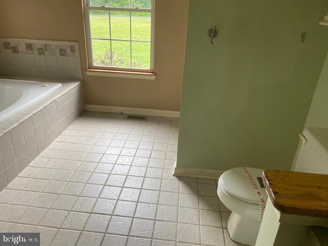 14413 Bittersweet Dr, Hughesville, MD 20637 - full bathroom with tile patterned flooring, baseboards, toilet, and a relaxing tiled tub