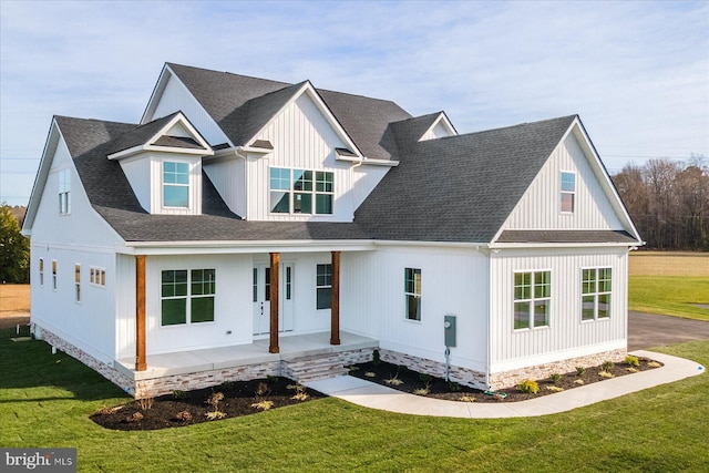 view of front of home with covered porch and a front lawn