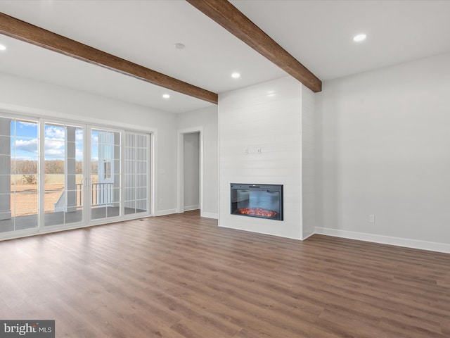 unfurnished living room with beamed ceiling, a fireplace, and hardwood / wood-style flooring