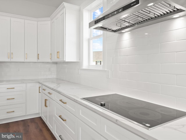 kitchen with dark wood-type flooring, light stone counters, black electric cooktop, white cabinets, and exhaust hood