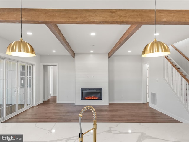 unfurnished living room featuring beamed ceiling, wood-type flooring, and a fireplace