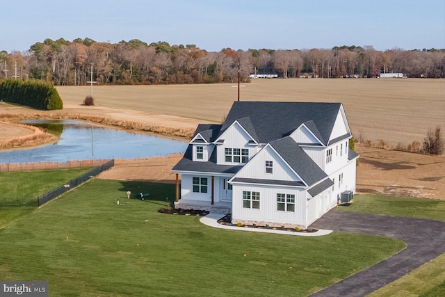 exterior space featuring central AC unit, a water view, and a front yard