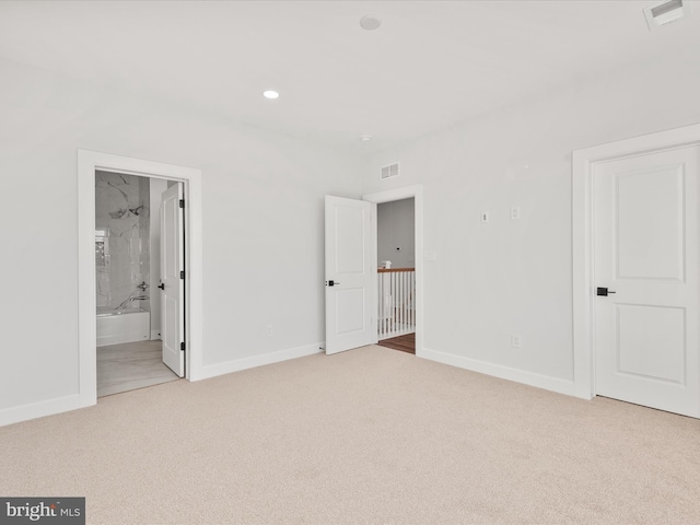 unfurnished bedroom with light carpet and ensuite bath