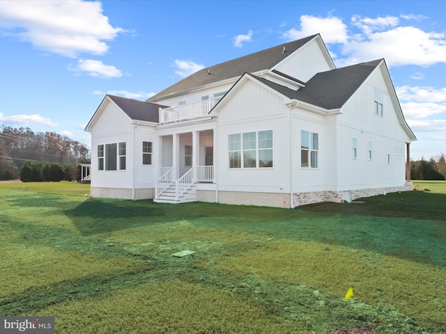 back of house with a lawn and a balcony