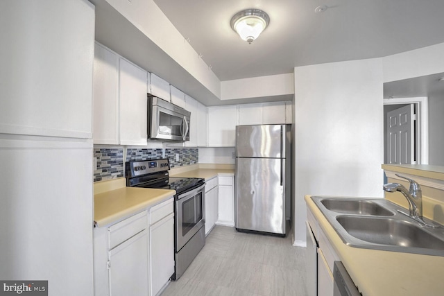 kitchen featuring white cabinets, stainless steel appliances, and sink