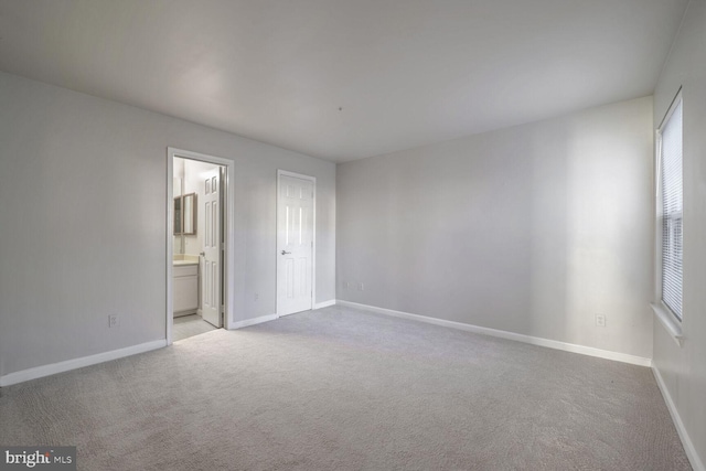 unfurnished bedroom with light carpet and ensuite bath