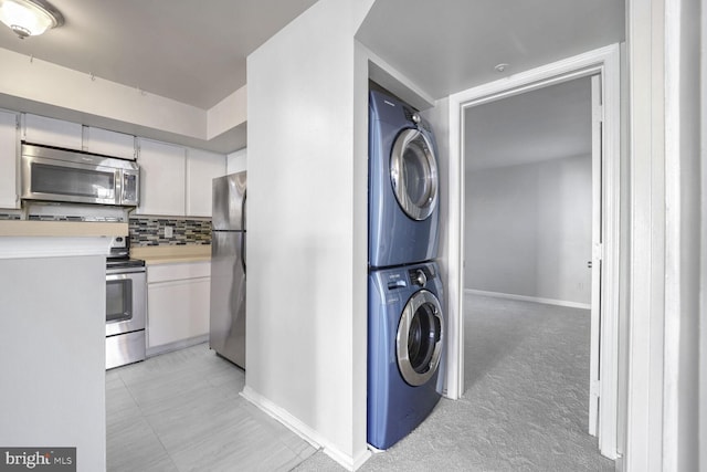 washroom featuring light carpet and stacked washer and clothes dryer