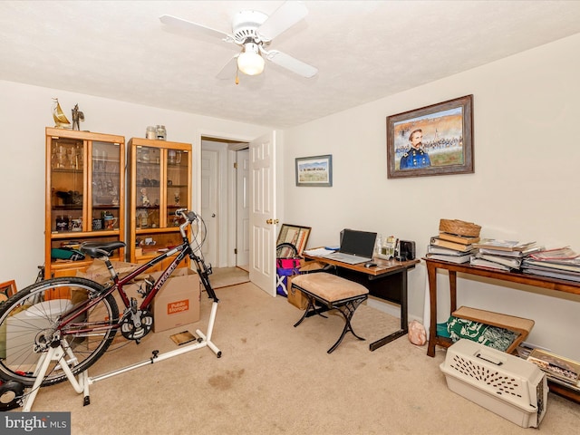 carpeted office featuring ceiling fan